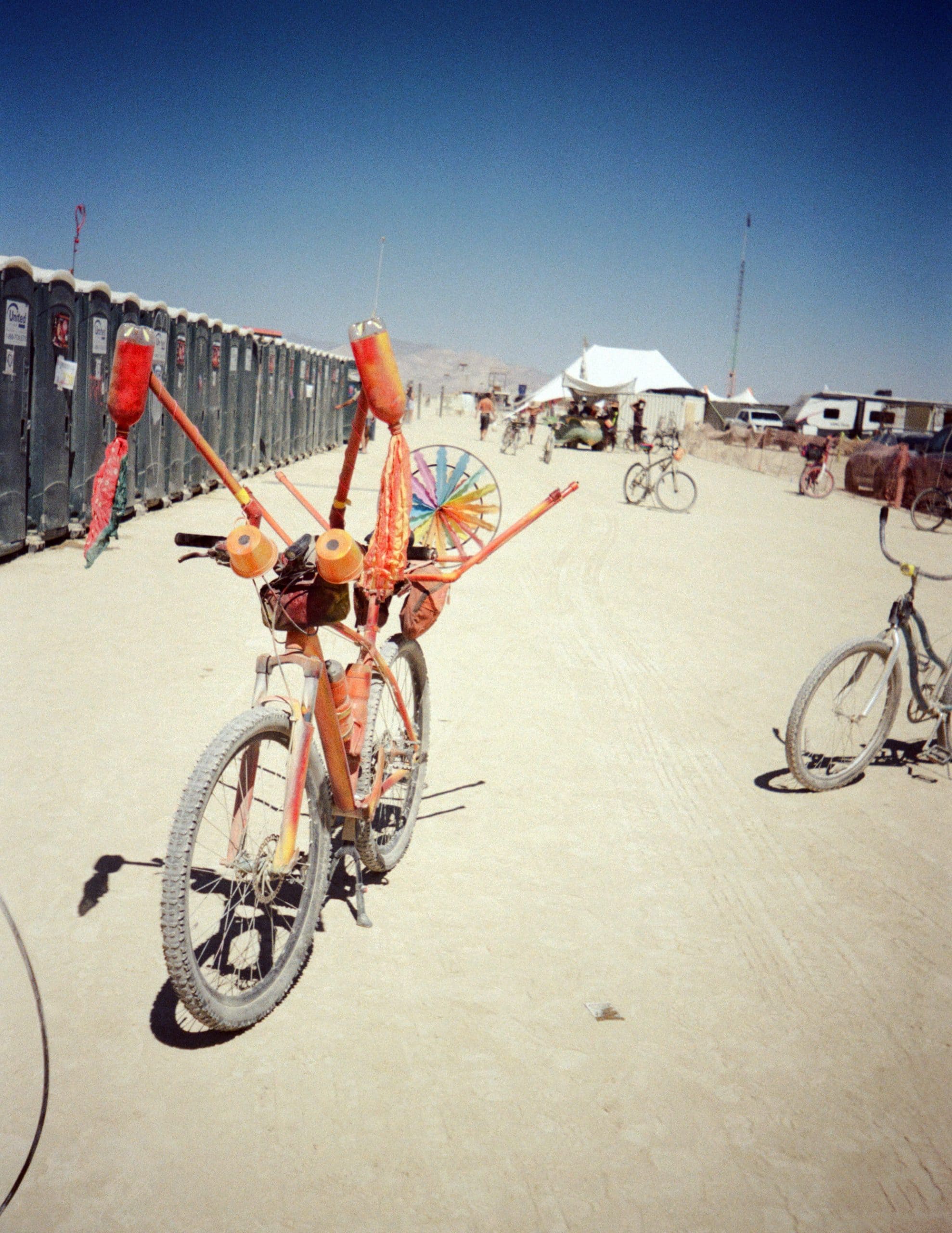 A decorated Burning Man bike next to the porta-potty bathrooms.