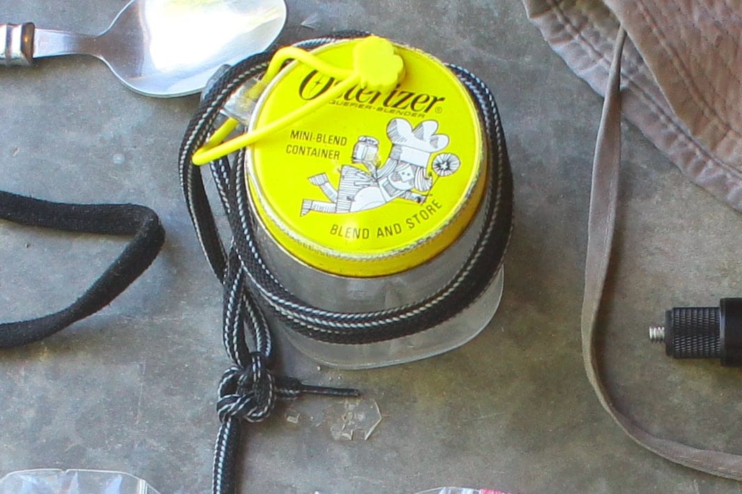 Vintage Osterizer mini blend container with an attached string and lid used as a portable cup as a packing list item for the Burning Man event.