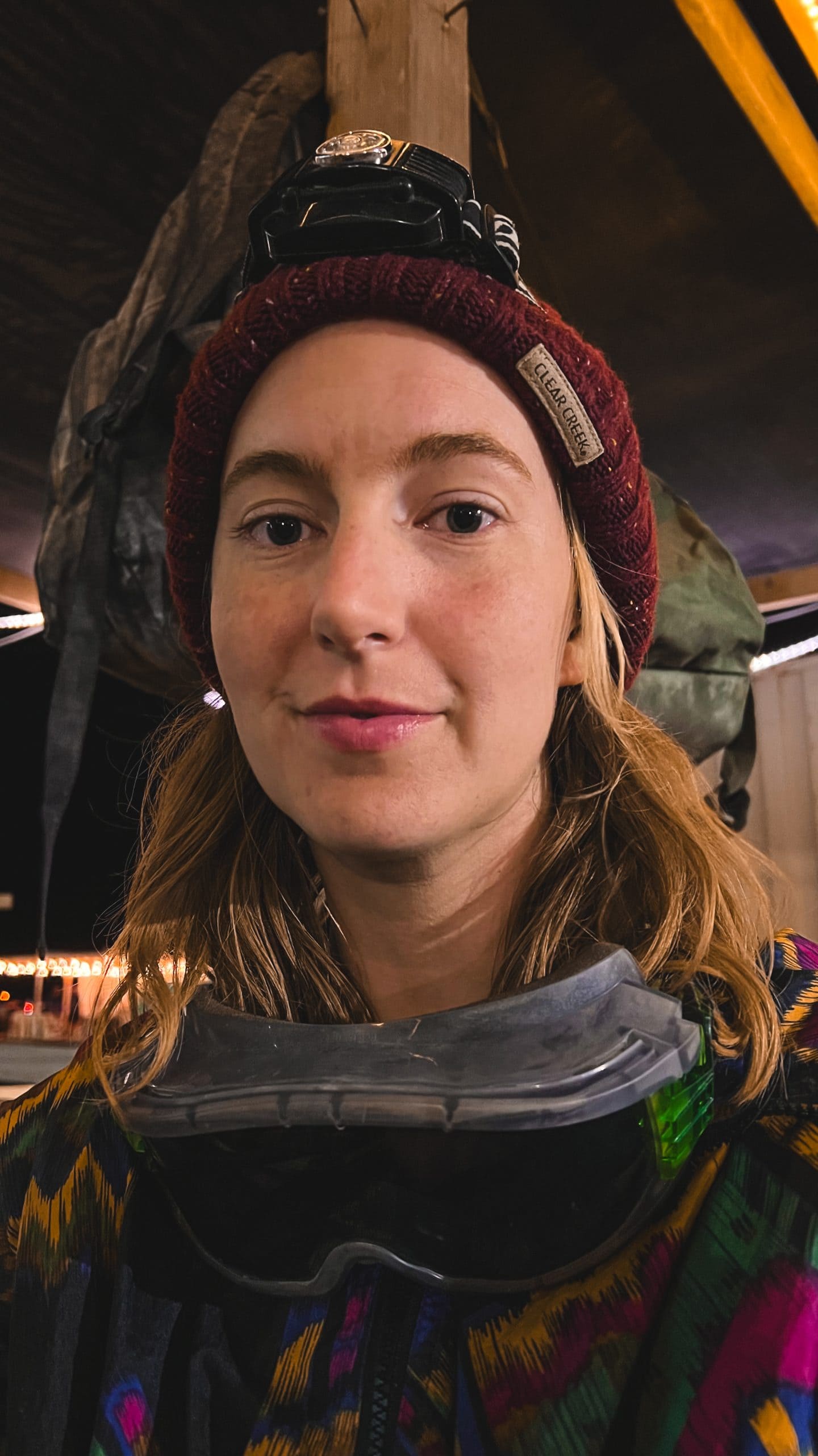 Tasha wearing a headlamp and goggles at Burning Man in a 90s vintage style jacket.