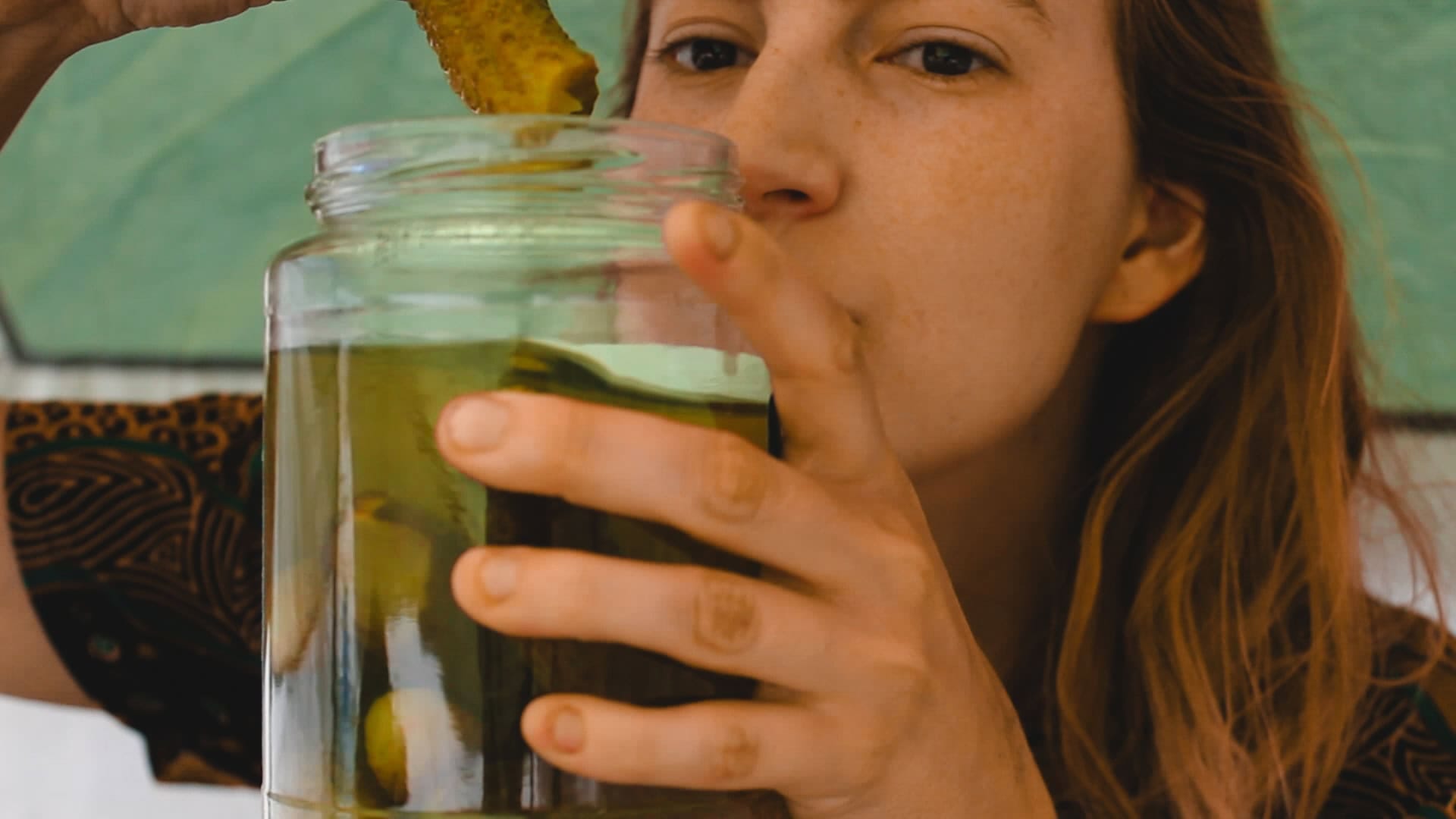 Tasha grabbing a pickle from the jar in her tent.
