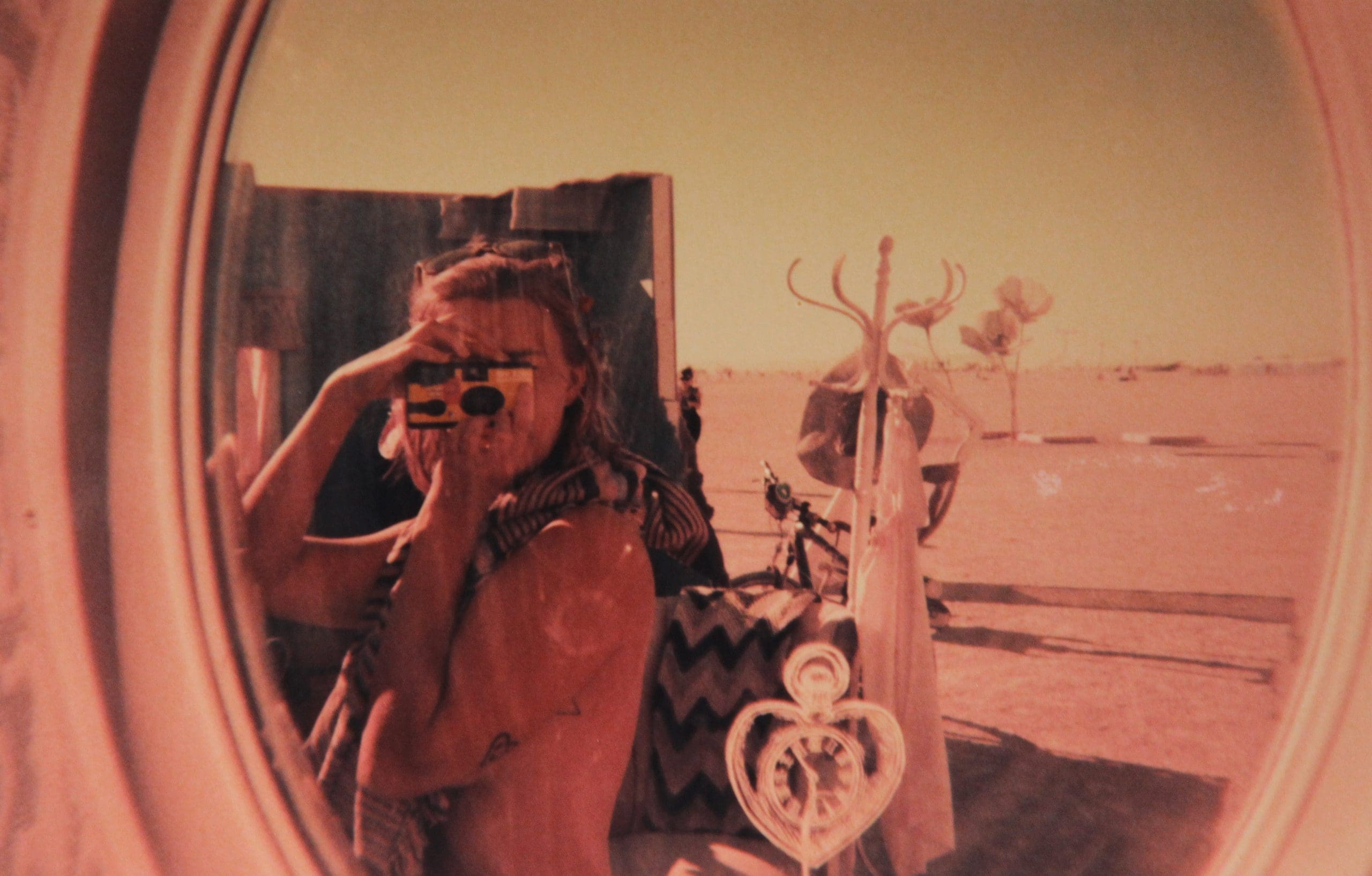 Taking a photo of my reflection in a mirror with a disposable camera on an art installation at Burning Man.