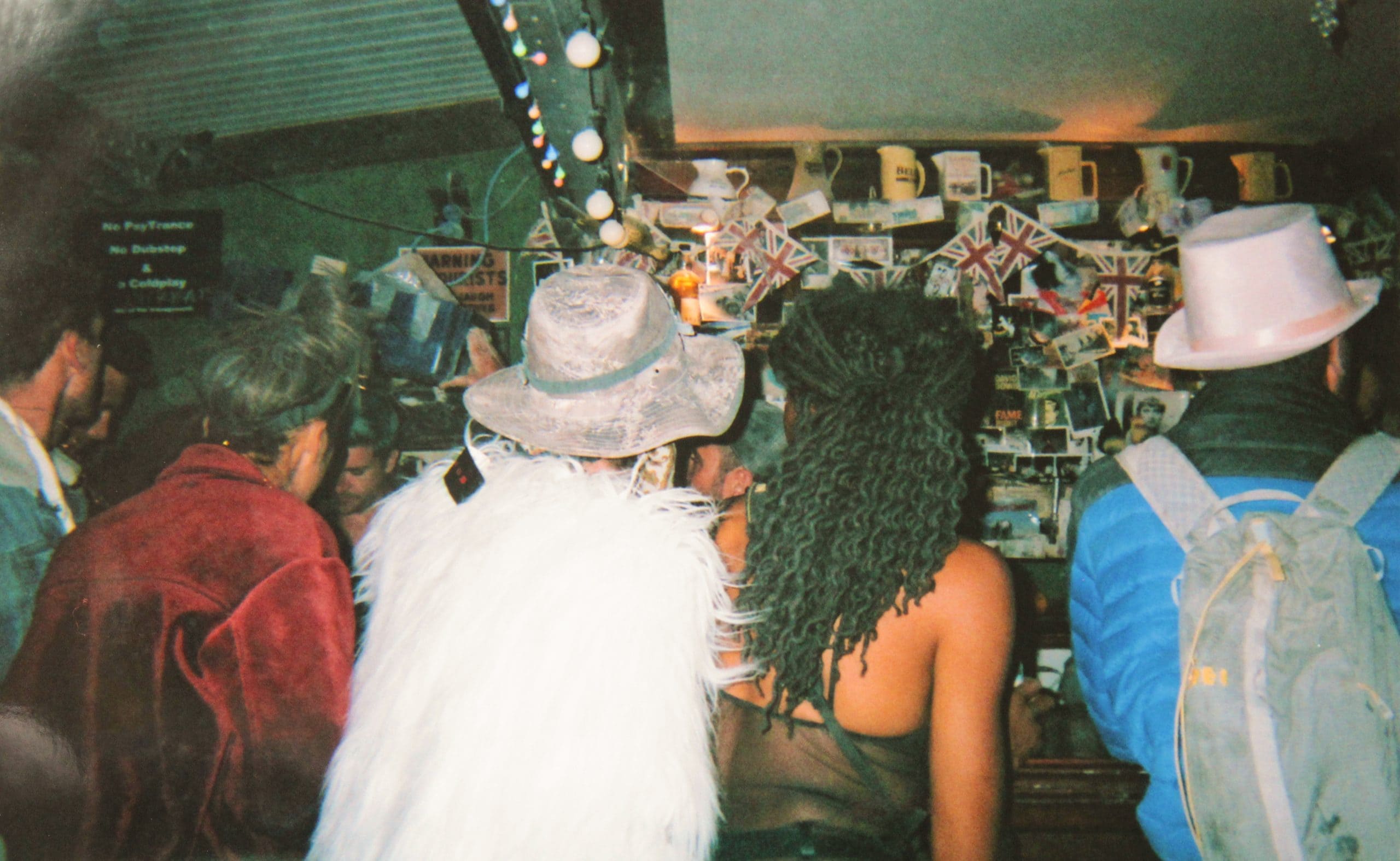 People standing facing a bar in an English style pub at Burning Man.