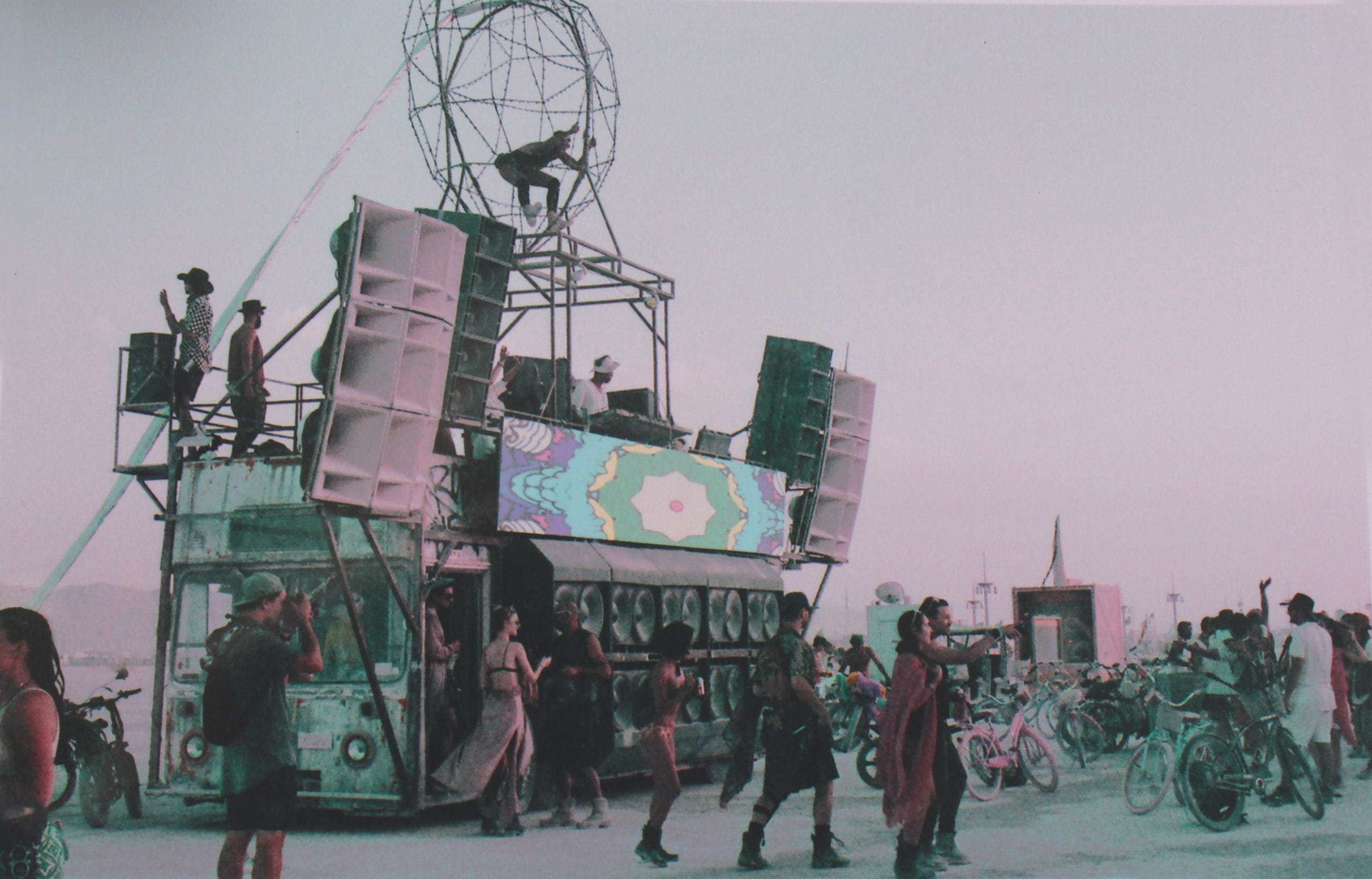 Robot heart art installation at Burning Man during sunrise with people dancing in front. Lomochrome purple film so it's tinted purple.