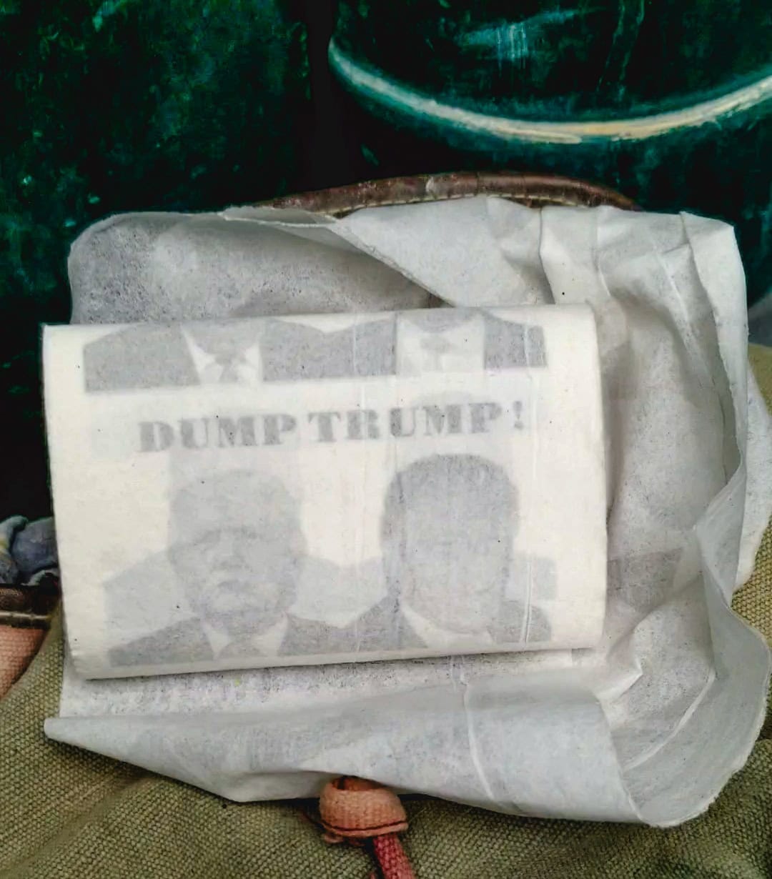 Roll of Single ply toilet paper with Donald Trump's face on it and text that says "Dump Trump." Inside a porta-potty in Black Rock City.